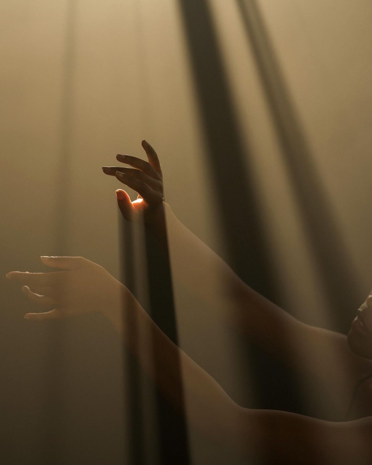 Two reaching hands in warm light, symbolising connection and care